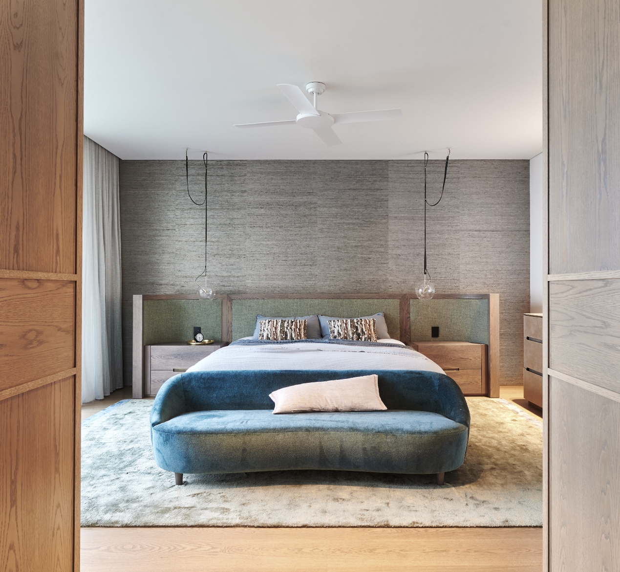 Modern bedroom with wooden furniture and blue accents.