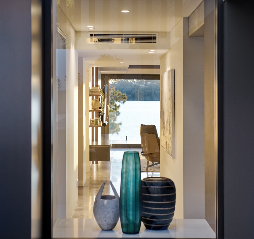 Elegant interior hallway with decorative vases and waterfront view.