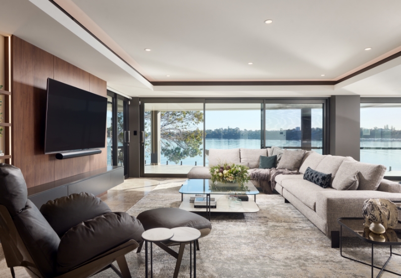 Modern living room with lake view through large windows.