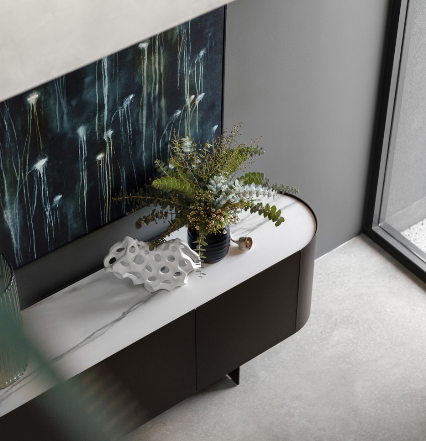 Modern console table with plant and abstract art.