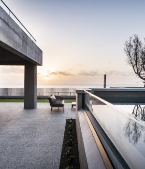 Modern seaside terrace at sunset with infinity pool.