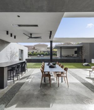 Modern outdoor patio with kitchen and dining area.